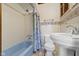 Bathroom with blue bathtub, vintage tile, and classic pedestal sink at 23 S Downey Ave, Indianapolis, IN 46219