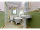 Charming bathroom features a clawfoot tub, pedestal sink, and tiled floors at 23 S Downey Ave, Indianapolis, IN 46219