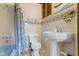 Retro bathroom boasts a blue bathtub, tile accents, and a traditional pedestal sink at 23 S Downey Ave, Indianapolis, IN 46219