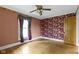 Vintage bedroom features colorful wallpaper, wood floors, and natural light at 23 S Downey Ave, Indianapolis, IN 46219