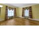 Bedroom with hardwood floors, yellow walls, crown molding, and patterned curtains provides comfort and classic charm at 23 S Downey Ave, Indianapolis, IN 46219
