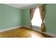Bedroom with hardwood floors and light green walls showcases a simple aesthetic, perfect for relaxation at 23 S Downey Ave, Indianapolis, IN 46219