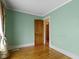 Bedroom features hardwood floors, fresh green walls, and an open doorway providing a welcoming atmosphere at 23 S Downey Ave, Indianapolis, IN 46219