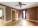 Bedroom with hardwood floors and light brown walls showcases a vintage ceiling fan and access to additional rooms at 23 S Downey Ave, Indianapolis, IN 46219