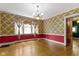 The dining room boasts an elegant chandelier, bright windows, and unique vintage wallpaper at 23 S Downey Ave, Indianapolis, IN 46219