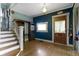 Spacious entryway with wooden staircase, built-in shelving, and hardwood floors at 23 S Downey Ave, Indianapolis, IN 46219