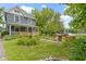 Two-story home with front porch, landscaped yard featuring colorful flowers, and a stone pathway leading to the entrance at 23 S Downey Ave, Indianapolis, IN 46219