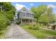 Two-story home with a front porch, a driveway leading to a detached garage, and landscaped yard at 23 S Downey Ave, Indianapolis, IN 46219