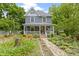 Charming two-story home featuring a welcoming front porch and professionally landscaped front yard with stone pathway at 23 S Downey Ave, Indianapolis, IN 46219