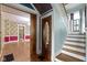Foyer with staircase, period-style doorway and access to floral wallpaper room at 23 S Downey Ave, Indianapolis, IN 46219