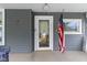 Close-up of the front door with an American flag displayed on a covered front porch at 23 S Downey Ave, Indianapolis, IN 46219