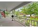 Covered front porch with white railings and an American flag, offering a view of the landscaped front yard at 23 S Downey Ave, Indianapolis, IN 46219