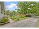 Landscaped front yard featuring a stone pathway, flowers, mature trees, and a glimpse of the home's exterior at 23 S Downey Ave, Indianapolis, IN 46219