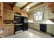 Kitchen featuring wood cabinetry, a black appliance package, and a cozy window view at 23 S Downey Ave, Indianapolis, IN 46219