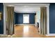 Large living room with hardwood floors, neutral curtains, and a decorative fireplace at 23 S Downey Ave, Indianapolis, IN 46219