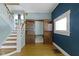 Living room with hardwood floors, a staircase, built-in shelving, and natural light at 23 S Downey Ave, Indianapolis, IN 46219