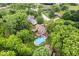 An aerial view showcases a house with a pool, deck, fenced yard, and mature trees at 259 Glenbrook Ln, Avon, IN 46123