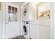 Efficient laundry room with stacked washer/dryer, storage cabinets, and exterior access, streamlining chores at 259 Glenbrook Ln, Avon, IN 46123
