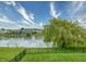 Picturesque backyard view with a serene lake, mature trees, and a black metal fence at 2615 Pumpkin Patch Ln, Indianapolis, IN 46229
