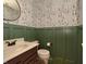 Charming bathroom features unique wallpaper and green wainscoting at 2615 Pumpkin Patch Ln, Indianapolis, IN 46229