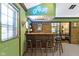 Stylish bar area with a neon sign, a brick backsplash, and ample seating for entertaining at 272 N Peterman Rd, Greenwood, IN 46142