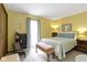 Comfortable bedroom with yellow walls, full sized bed, bench seat, bookshelf, and window with natural light at 272 N Peterman Rd, Greenwood, IN 46142