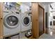 Functional laundry room with washer, dryer, storage shelves, and hardwood floors at 272 N Peterman Rd, Greenwood, IN 46142