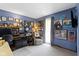 Well-lit home office with blue walls, desk, sitting chair, and gallery wall displaying artwork and Gathering photos at 272 N Peterman Rd, Greenwood, IN 46142