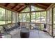 Screened porch with wood beams, bench, decorative glass details, table, and ceiling fan at 272 N Peterman Rd, Greenwood, IN 46142