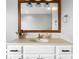 Close-up of bathroom vanity featuring a wood-framed mirror, neutral countertop, and white cabinets with black hardware at 2872 N Prairie Stream Way, Columbus, IN 47203