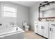 Bright bathroom with a soaking tub, white cabinets, and neutral tiling for a clean, modern feel at 2872 N Prairie Stream Way, Columbus, IN 47203