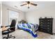 Well-lit bedroom featuring a comfy bed, ceiling fan, and a dark dresser, perfect for relaxation and rest at 2872 N Prairie Stream Way, Columbus, IN 47203