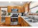 Well-lit kitchen boasts stainless steel appliances, oak cabinets, and backyard views at 2872 N Prairie Stream Way, Columbus, IN 47203