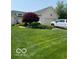 Well-maintained front yard featuring a brick home, lush lawn, and landscaping at 3354 Nottinghill Dr, Plainfield, IN 46168