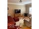 Comfortable living room with a red leather couch, neutral walls, and a patterned area rug at 3354 Nottinghill Dr, Plainfield, IN 46168