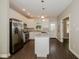 Modern kitchen boasting white cabinets, stainless steel appliances, a central island, and luxury vinyl plank flooring at 3626 N Capitol Ave, Indianapolis, IN 46208