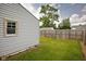 Spacious backyard featuring a wood fence, green grass, and mature trees providing ample shade at 3822 Haverhill Dr, Anderson, IN 46013