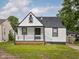 Charming home with a covered front porch, black and white trim and a well-manicured lawn at 3822 Haverhill Dr, Anderson, IN 46013