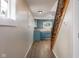 Hallway view of a blue kitchen featuring wood floors, natural light, and wooden stairs at 3822 Haverhill Dr, Anderson, IN 46013