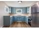 Bright, updated kitchen with blue cabinets, stainless steel appliances, and wood floors at 3822 Haverhill Dr, Anderson, IN 46013