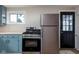 Stainless steel gas range and refrigerator in kitchen with blue cabinetry and wood flooring at 3822 Haverhill Dr, Anderson, IN 46013