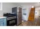 View of a kitchen featuring stainless steel appliances and a wooden staircase leading upstairs at 3822 Haverhill Dr, Anderson, IN 46013