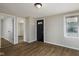 Bright living room features wood-look flooring, neutral paint, a modern light fixture, and a black front door at 3822 Haverhill Dr, Anderson, IN 46013