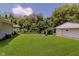 Expansive backyard featuring green lawn, trees, and detached garage, ideal for outdoor activities at 4218 E 18Th St, Indianapolis, IN 46218