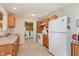 Efficient kitchen with white appliances, wood cabinets, and a glimpse of the laundry room at 4218 E 18Th St, Indianapolis, IN 46218