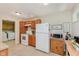 Functional kitchen with white appliances, wood cabinets, and view into laundry room at 4218 E 18Th St, Indianapolis, IN 46218