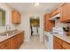 Cozy kitchen featuring wooden cabinetry and white appliances, open to the laundry area at 4218 E 18Th St, Indianapolis, IN 46218