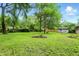Spacious backyard featuring green grass, tall trees, and a shed, providing a serene outdoor space at 4340 Ashbourne Ln, Indianapolis, IN 46226