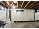 Unfinished basement with storage cabinets, exposed ceiling, and laundry area, ready for customization at 4340 Ashbourne Ln, Indianapolis, IN 46226