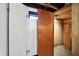 Basement storage room with wood door and view into unfinished area, ready for personalization and improvements at 4340 Ashbourne Ln, Indianapolis, IN 46226